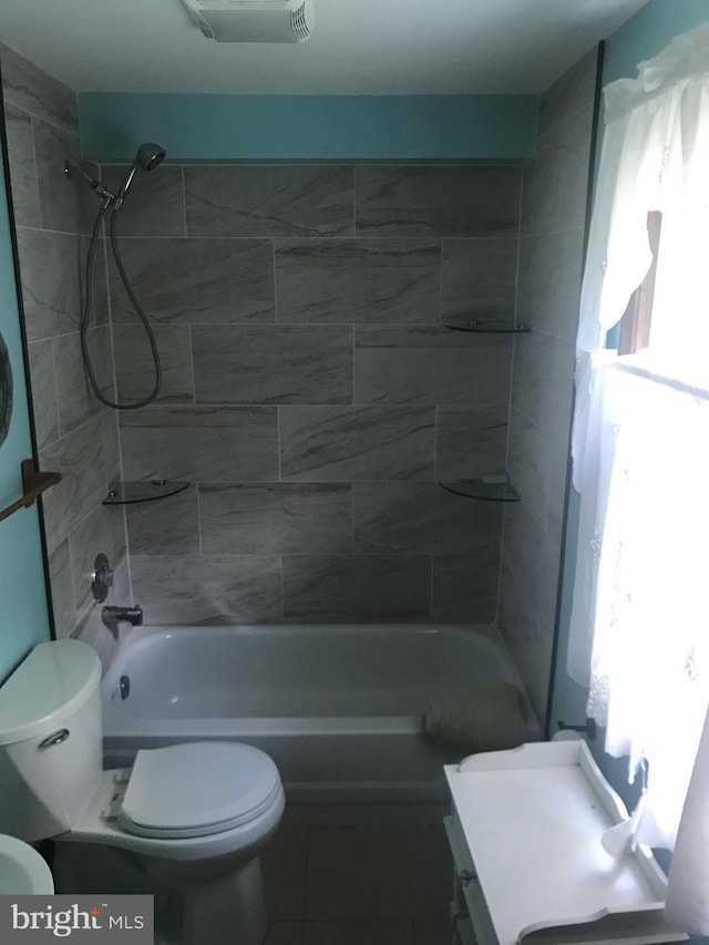 full bathroom featuring tiled shower / bath combo, toilet, and vanity