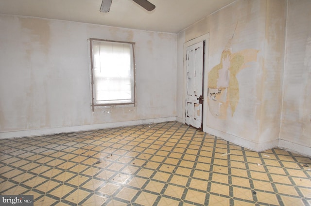 tiled empty room featuring ceiling fan