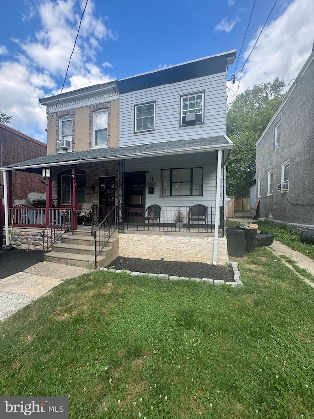 view of front facade featuring a front yard and covered porch