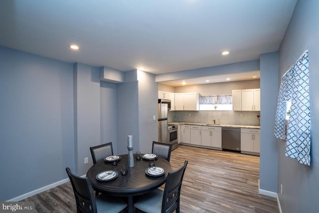 dining room featuring recessed lighting, baseboards, and light wood-type flooring