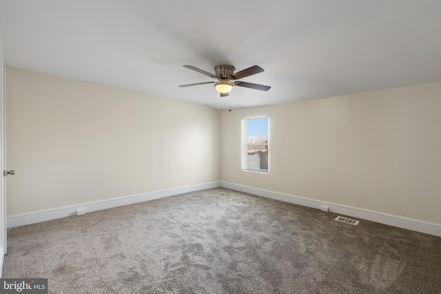 spare room with ceiling fan and carpet