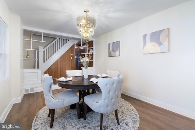 dining room with dark wood-type flooring and an inviting chandelier