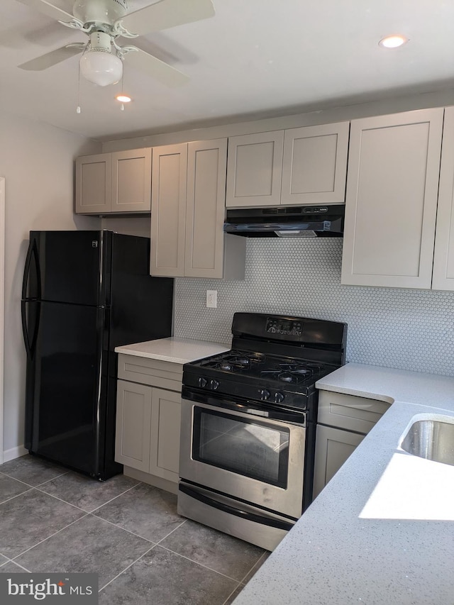 kitchen featuring black refrigerator, stainless steel range with gas cooktop, ceiling fan, and gray cabinetry