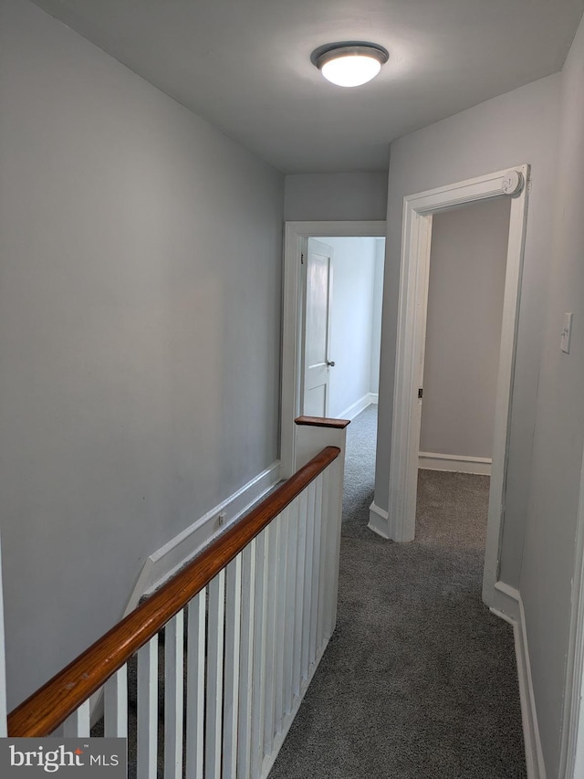 hallway featuring dark colored carpet