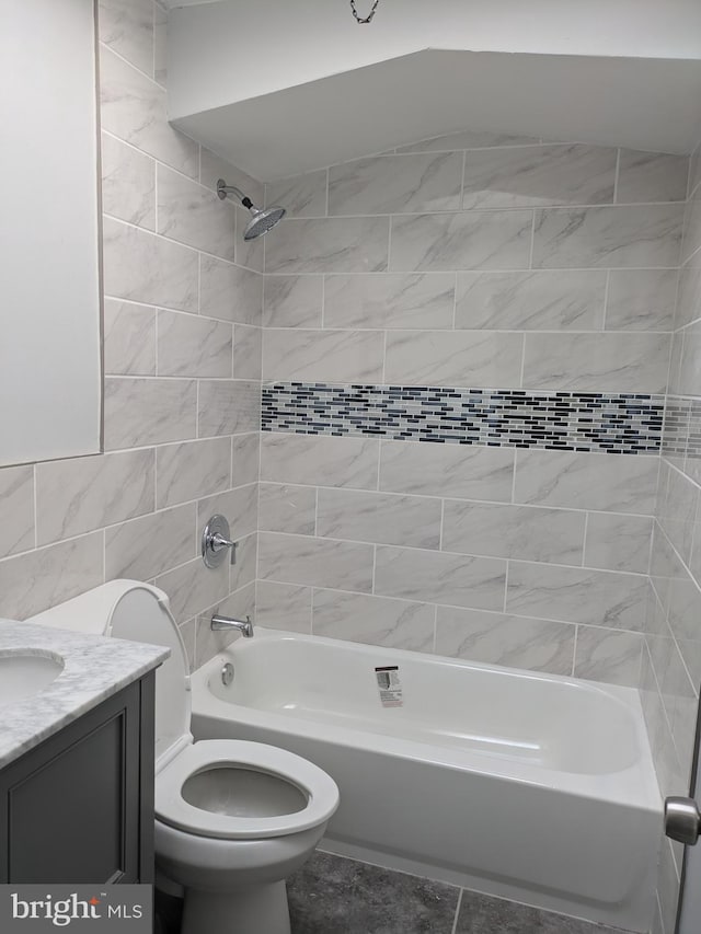 full bathroom with toilet, vanity, tile walls, and tiled shower / bath