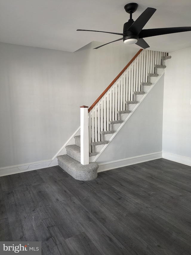 stairway with hardwood / wood-style floors and ceiling fan