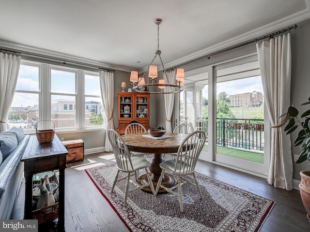 dining area featuring dark hardwood / wood-style flooring, ornamental molding, and an inviting chandelier