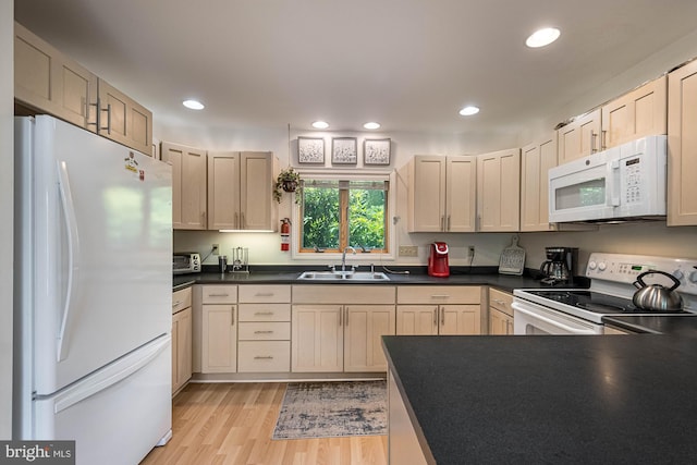 kitchen featuring white appliances, sink, and light hardwood / wood-style flooring