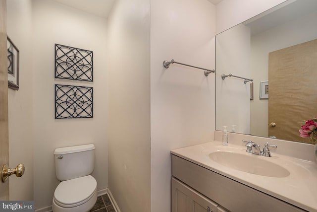 bathroom featuring tile patterned flooring, vanity, and toilet