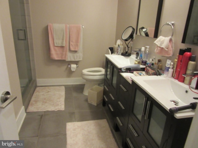 bathroom with a shower with shower door, vanity, toilet, and tile patterned floors