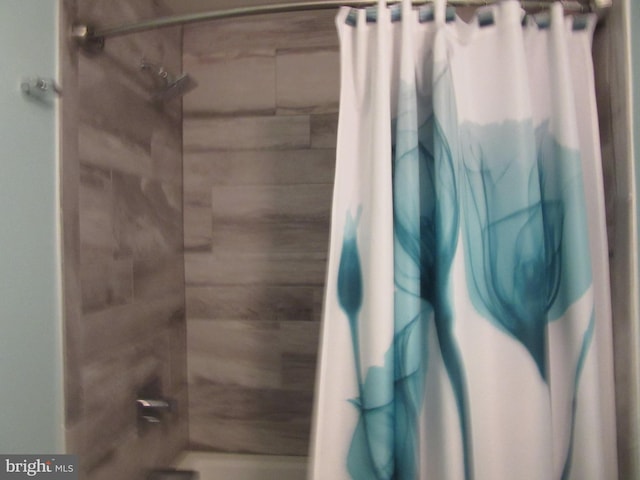 bathroom with shower / bath combo with shower curtain