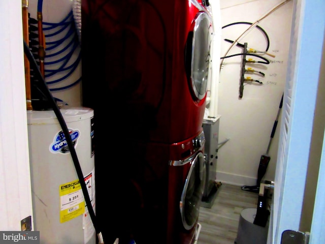 interior space with electric water heater, hardwood / wood-style flooring, and stacked washer and dryer