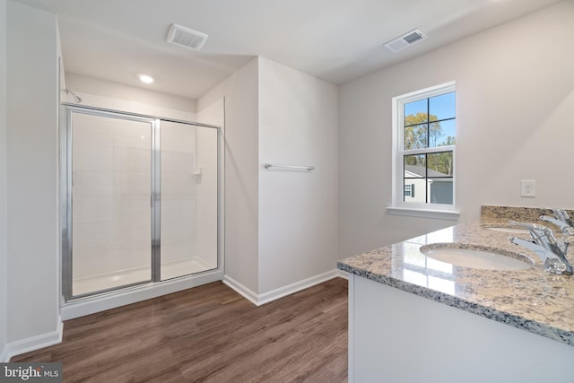 bathroom with walk in shower, vanity, and hardwood / wood-style flooring