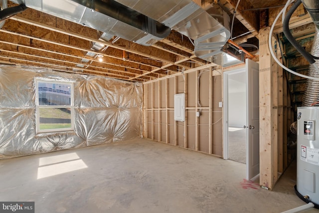 basement featuring electric panel and electric water heater