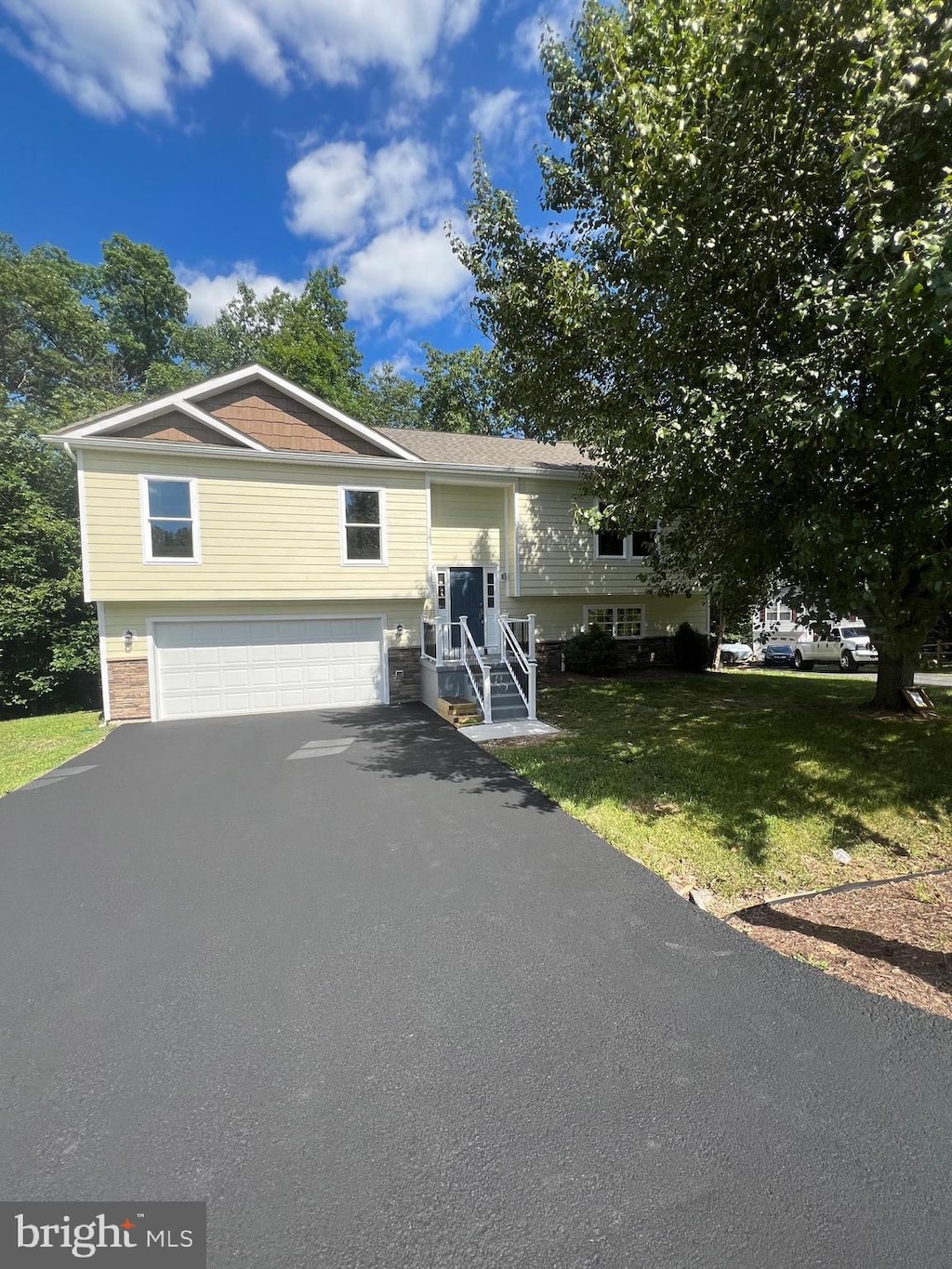 bi-level home featuring a garage and a front lawn