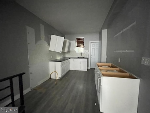 kitchen featuring white cabinets, dark wood-type flooring, and sink