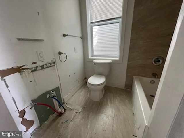 bathroom featuring a tub and toilet