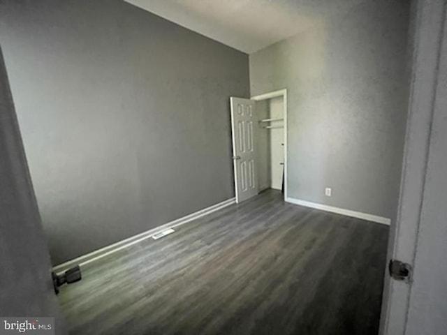 unfurnished bedroom with dark hardwood / wood-style flooring