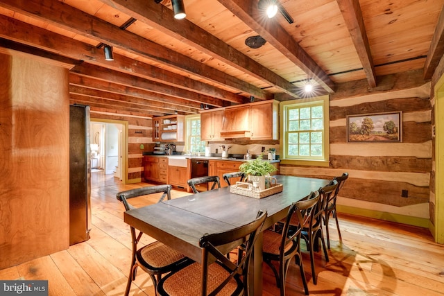 dining room with beamed ceiling, light hardwood / wood-style floors, wooden walls, and wood ceiling