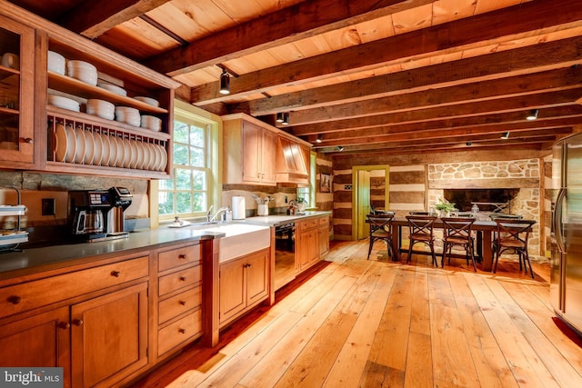 kitchen featuring light wood-type flooring, sink, wooden ceiling, beamed ceiling, and black dishwasher