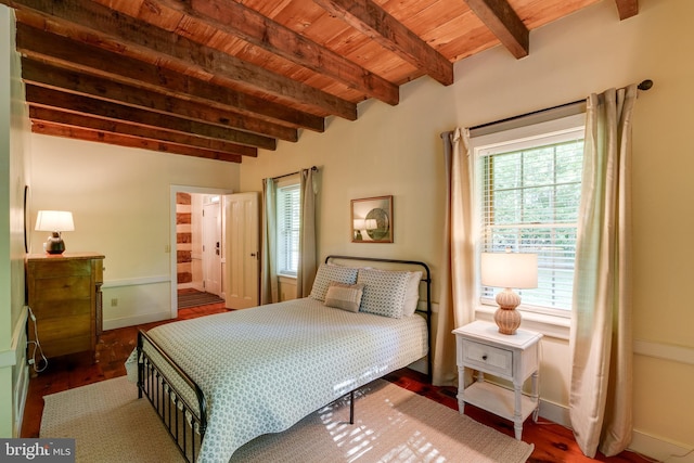 bedroom featuring beamed ceiling, ensuite bathroom, dark hardwood / wood-style flooring, and wood ceiling