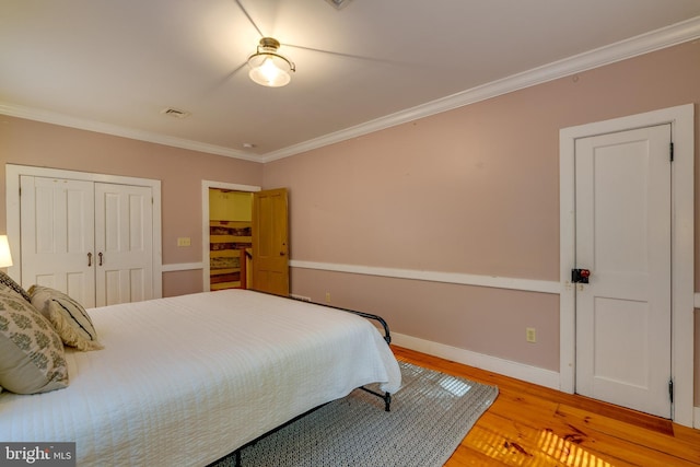 bedroom with wood-type flooring and ornamental molding