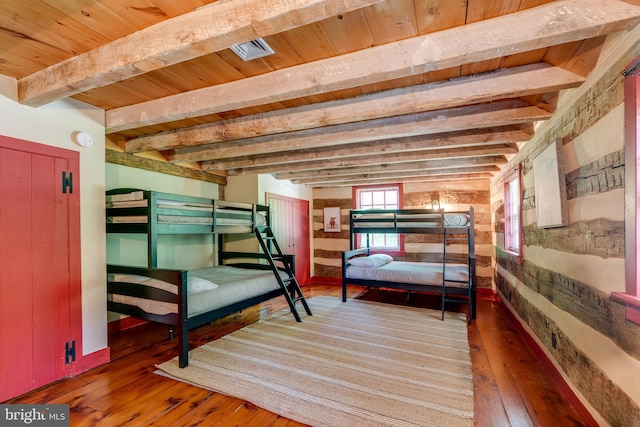 bedroom featuring beam ceiling, dark hardwood / wood-style flooring, and wooden ceiling