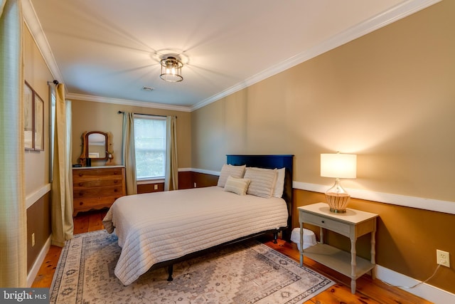 bedroom featuring hardwood / wood-style flooring and crown molding