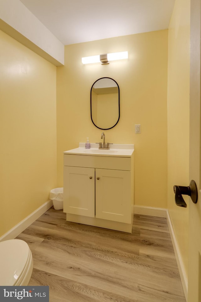 bathroom with vanity, wood-type flooring, and toilet