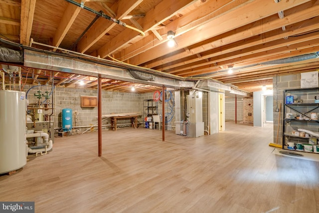 basement featuring gas water heater, wood-type flooring, and heating unit