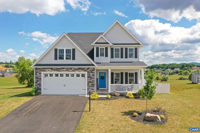 craftsman inspired home featuring a garage, covered porch, and a front lawn