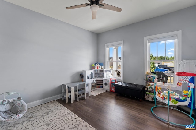 game room with dark wood-type flooring and ceiling fan