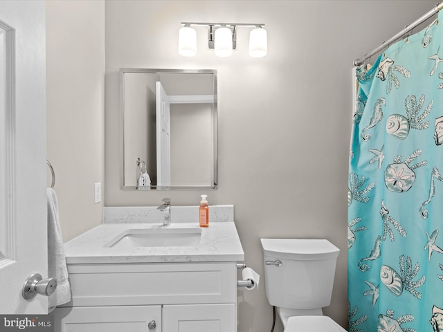 bathroom with a shower with curtain, vanity, and toilet