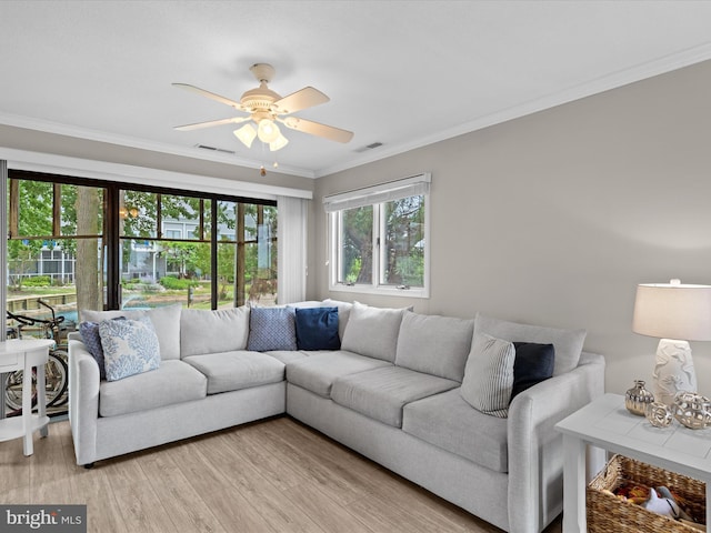 living room with light wood-type flooring, ceiling fan, and ornamental molding