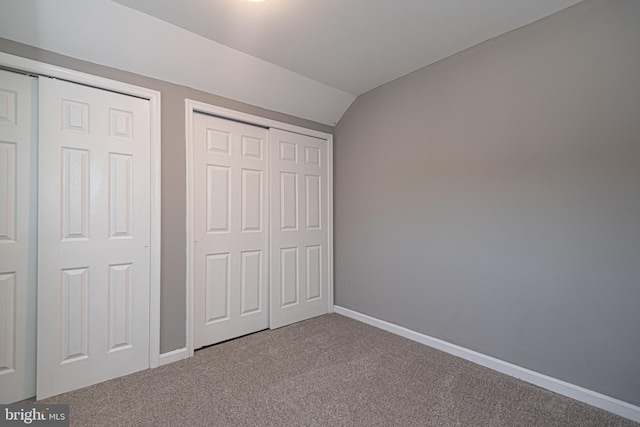 unfurnished bedroom with carpet and lofted ceiling