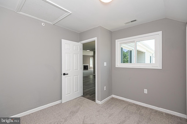 unfurnished bedroom with light carpet and lofted ceiling