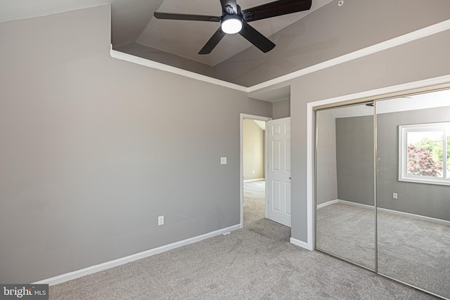 unfurnished bedroom with a closet, vaulted ceiling, ceiling fan, and light colored carpet