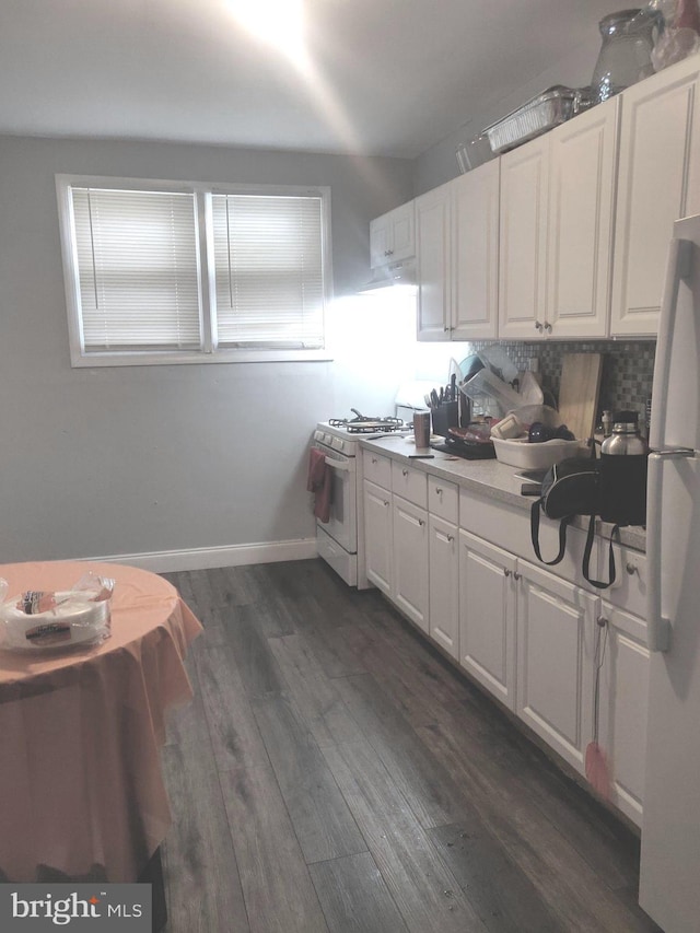 kitchen featuring decorative backsplash, white cabinetry, dark wood-type flooring, and white appliances