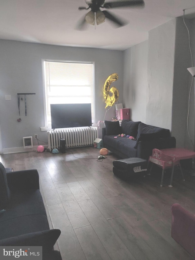 living room featuring hardwood / wood-style floors, radiator, and ceiling fan