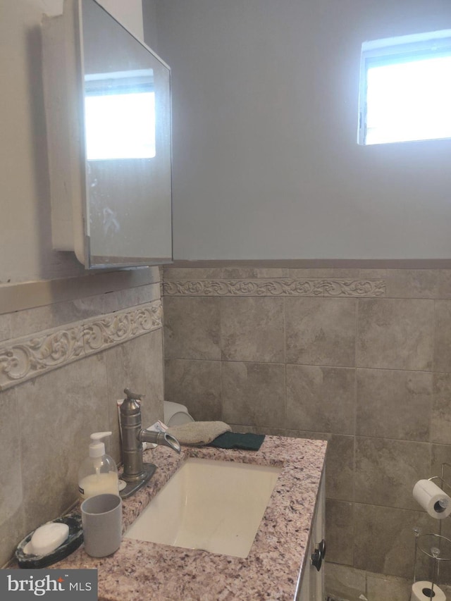 bathroom featuring vanity and tile walls