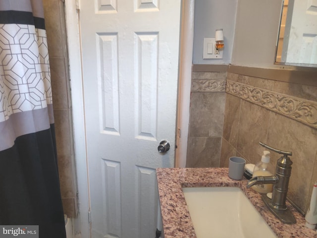 bathroom with vanity and tile walls