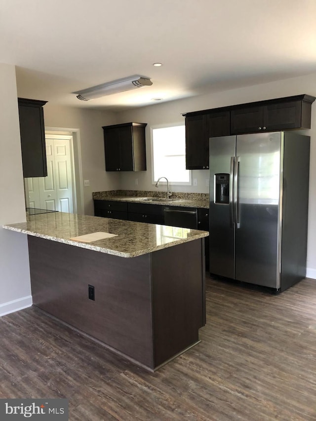 kitchen featuring dark wood-type flooring, sink, kitchen peninsula, and stainless steel fridge with ice dispenser