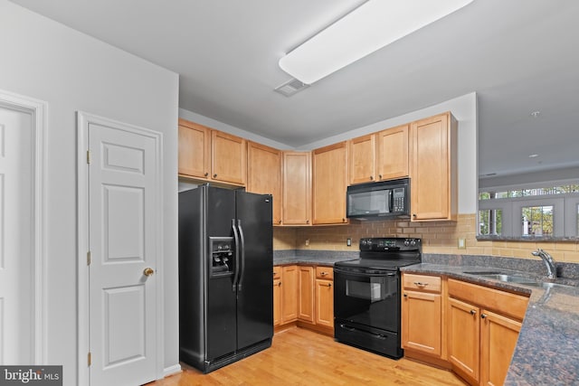 kitchen with black appliances, light brown cabinets, light wood-type flooring, and sink