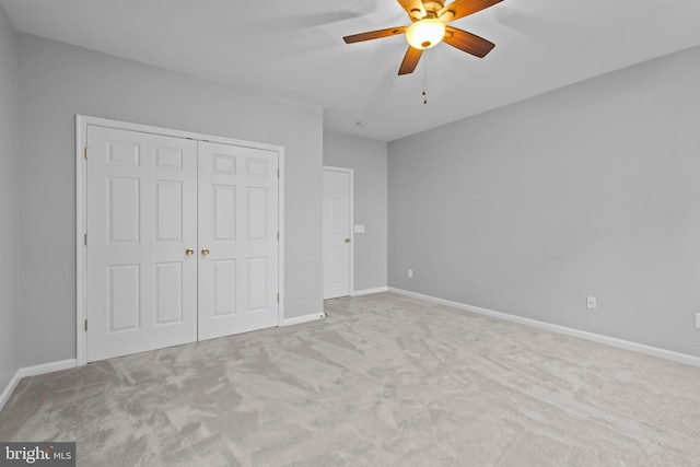 unfurnished bedroom with ceiling fan, light carpet, and a closet