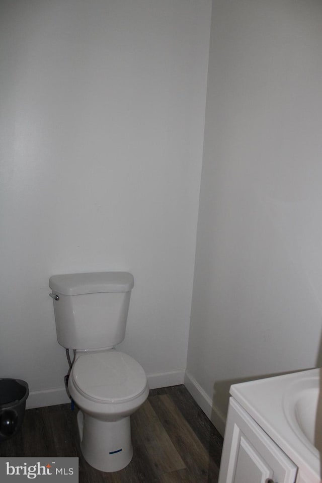 bathroom with toilet, vanity, and hardwood / wood-style flooring