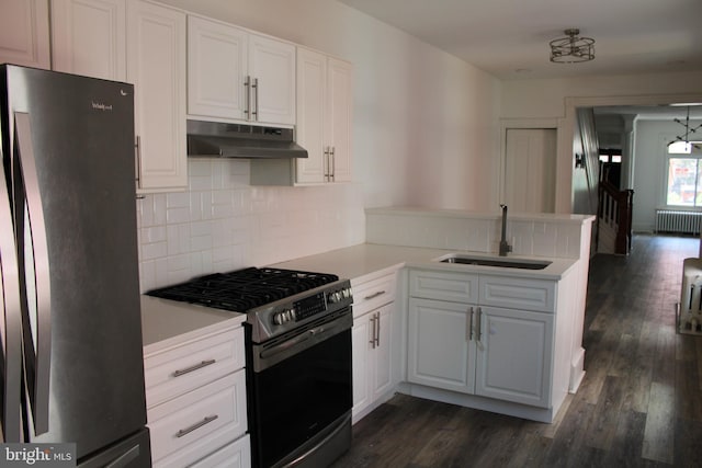 kitchen with sink, white cabinets, radiator heating unit, stainless steel gas stove, and fridge