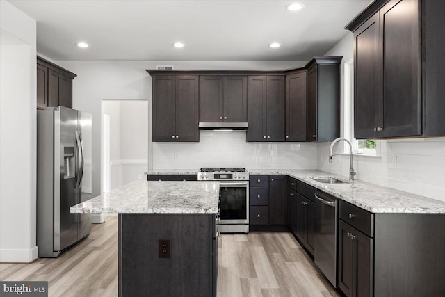 kitchen featuring a center island, sink, appliances with stainless steel finishes, light hardwood / wood-style floors, and dark brown cabinetry