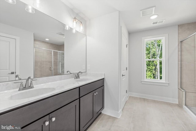 bathroom featuring tile patterned floors, vanity, and a shower with shower door