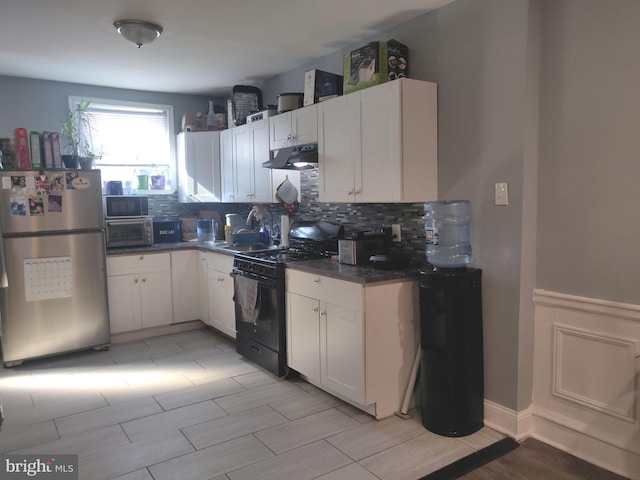 kitchen with white cabinetry, sink, tasteful backsplash, black electric range oven, and stainless steel fridge