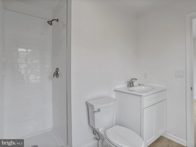bathroom with a shower stall, toilet, baseboards, and vanity